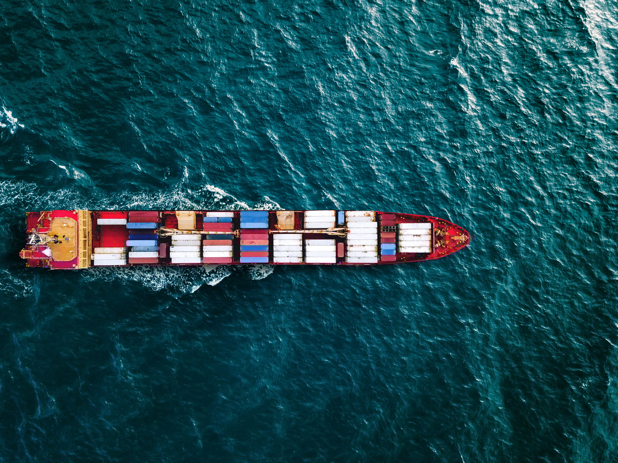 Aerial top view container ship vessel cargo carrier at blue sea.